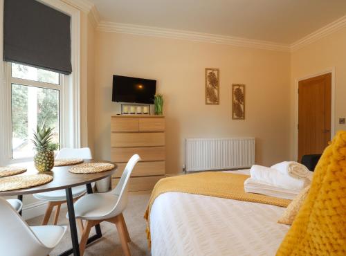 a bedroom with a bed and a table and a tv at Tow Beds, Close to Town, Beach, Hospital, Free Parking in Eastbourne