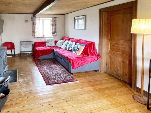 un soggiorno con divano rosso in una camera di 7 person holiday home in Löderup a Löderup