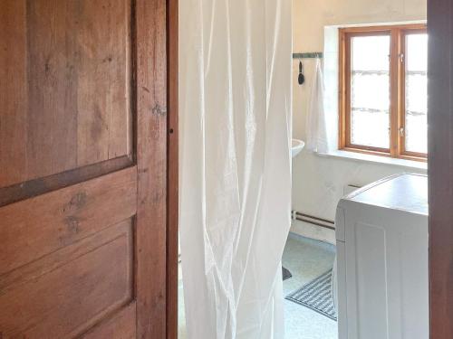 eine Tür zu einem Bad mit einem Waschbecken und einem Fenster in der Unterkunft Holiday home Löderup III in Löderup