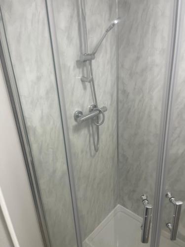 um chuveiro com uma porta de vidro na casa de banho em ODF foundation apartments em Strood