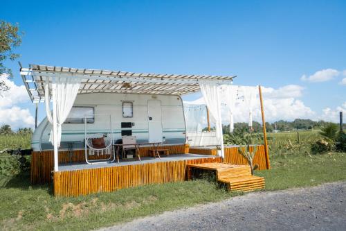 an rv with awning and a table and chairs at Happy Farm Village in Mae Taeng