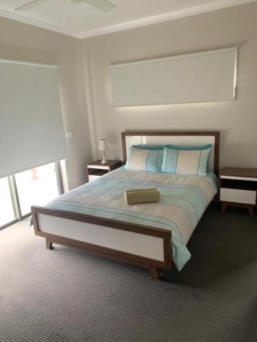 1 dormitorio con 1 cama grande con almohadas azules y blancas en Peterborough Getaway en Peterborough
