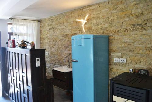 a blue refrigerator in a room with a brick wall at Lotca lu Vasile in Crisan
