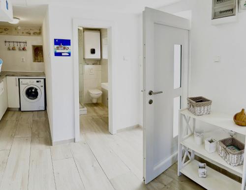 a laundry room with a washer and dryer and a door at Secret House Andrea in Primošten