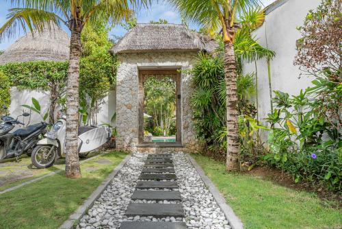 a door to a house with a motorcycle parked in front at Oasis Bungalows in Uluwatu