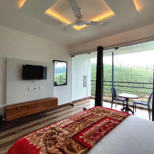 a bedroom with a bed and a flat screen tv at Green Mount Homestay in Vālpārai