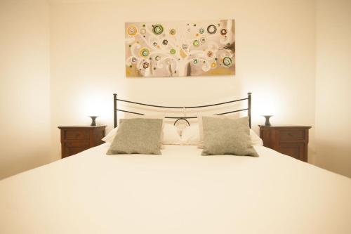 a bedroom with a white bed with two pillows at Casa vacanze Castello in Frontone