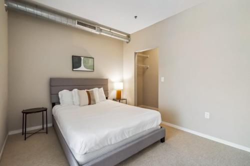 a bedroom with a large white bed in a room at CozySuites 2BR Mill District with pool, gym #02 in Minneapolis