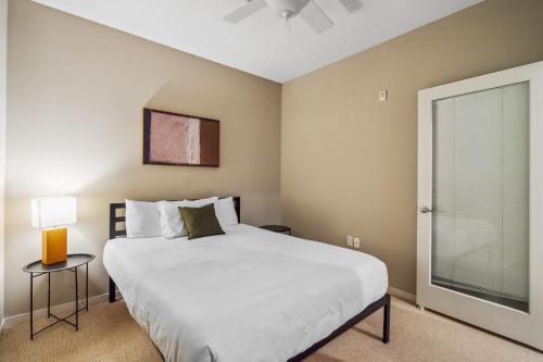 Un dormitorio con una gran cama blanca y una ventana en CozySuites 2BR Mill District pool gym # 02 en Minneápolis