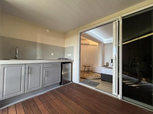 Ononui Airport Studio في فا: مطبخ مع باب زجاجي منزلق يؤدي إلى غرفة النوم