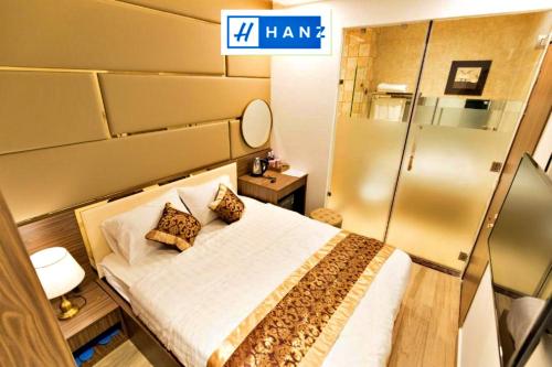 a small room with a bed and a mirror at HANZ MyMy Hotel in Ho Chi Minh City