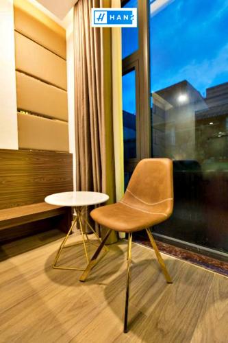 uma cadeira e uma mesa num quarto com uma janela em HANZ MyMy Hotel em Cidade de Ho Chi Minh