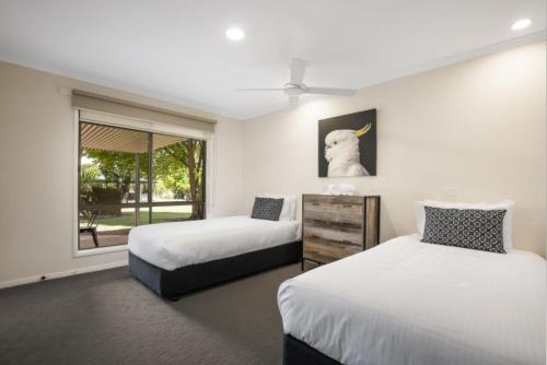 a bedroom with two beds and a window at Lakeside Country Club in Numurkah