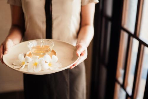 a woman holding a bowl with flowers on it at RIHGA Royal Laguna Guam Resort in Tamuning