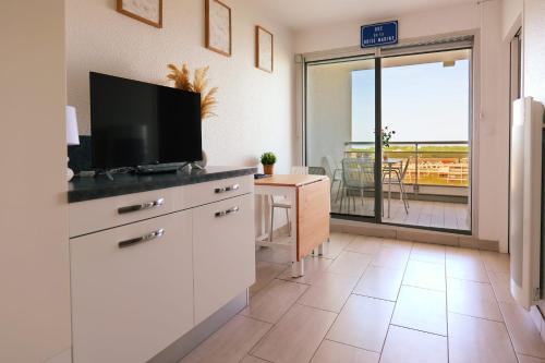 eine Küche mit einem Flachbild-TV und ein Wohnzimmer in der Unterkunft Nice studio with view in La Grande Motte - Welkeys in La Grande-Motte