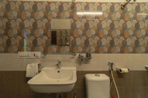 a bathroom with a white sink and a toilet at Dumas Guest House in Puducherry