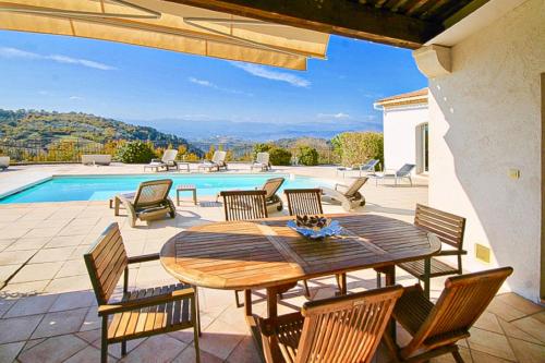un patio avec une table et des chaises et une piscine dans l'établissement Country villa - Sleeps 8 - Mimosa view, à Tanneron