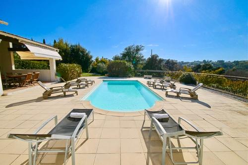 une piscine avec des chaises longues et une table dans l'établissement Country villa - Sleeps 8 - Mimosa view, à Tanneron