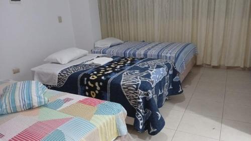 ein Zimmer mit 3 Betten und Decken darauf in der Unterkunft Huaras hostel in Huaraz