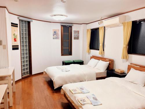 a room with two beds and a desk and windows at 三木屋Mikiya 名古屋駅徒步约600m 独栋别墅120平 3卧室5床2浴室2卫生间 24小时便利店 in Nagoya