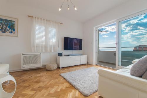 a living room with a couch and a large window at Apartments Jagoda in Makarska