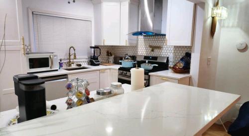 una cucina con armadi bianchi e piano di lavoro bianco di SEA BREEZE of Long Beach NY a Long Beach