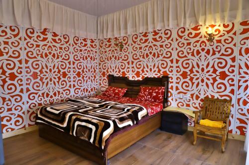 a bedroom with a bed and a red and white patterned wall at MUSSOORIE ADVENTURE RESORT in Mussoorie