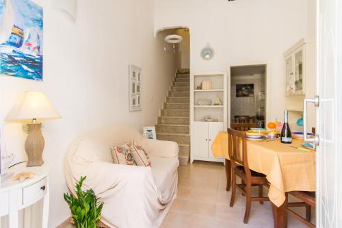 uma sala de estar com uma mesa e uma cadeira em Libeccio House - Happy Rentals em Avola