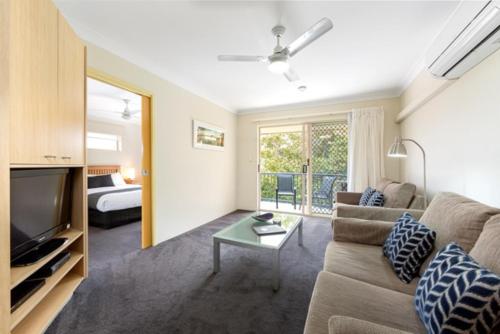 a living room with a couch and a tv and a bed at Tamarind Sands Resort in Cabarita Beach