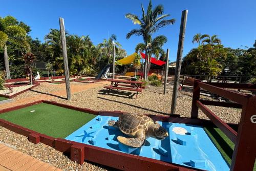 a turtle is laying on a miniature golf course at Tamarind Sands Resort in Cabarita Beach