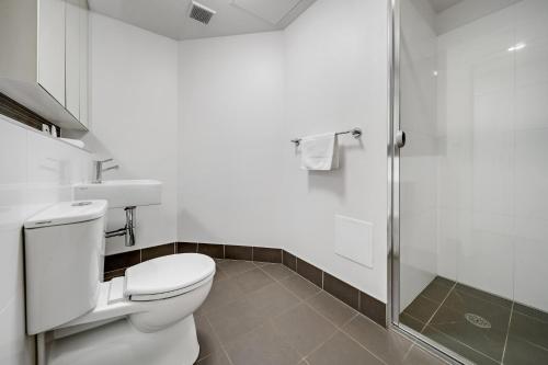 a bathroom with a toilet and a shower at Comfy Lakeside 1-Bed with Secure Parking in Tuggeranong
