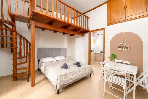 a bedroom with a bed and a staircase and a desk at Dionysia Sea Side By Greece Apartments in Selianitika