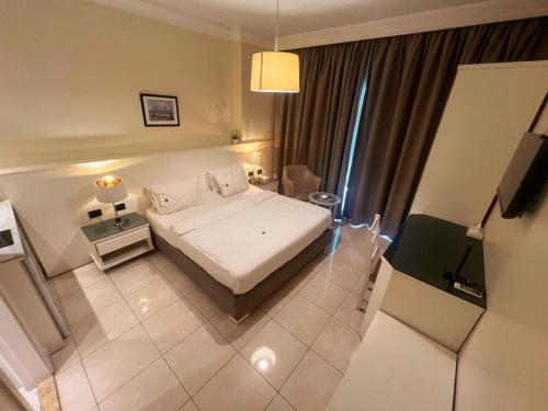 1 dormitorio con 1 cama y TV en Ny Suites, en Beirut