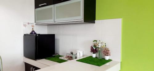 een keuken met een aanrecht met groen en wit bij De Viana Apartments Homestay in Kota Bharu