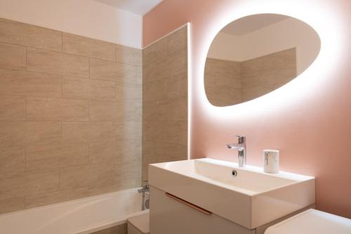 une salle de bain avec un lavabo et un miroir dans l'établissement Pretty cocoon of love close to the City of Light, à Montrouge
