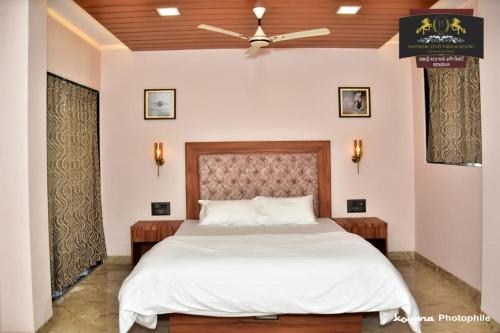 a bedroom with a large bed with a ceiling fan at Sahyadri Stud Farm & Resort in Mahabaleshwar