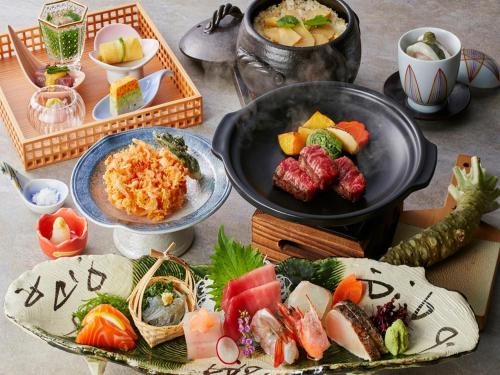 una mesa cubierta con platos de comida y tazones de comida en KAMENOI HOTEL Yaizu en Yaizu