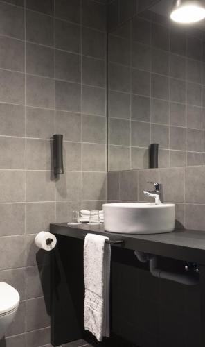 a bathroom with a sink and a toilet at Skuggi Hotel by Keahotels in Reykjavík