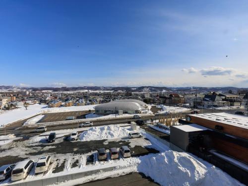 a view of a city with snow covered roofs at Tabist Kitami Athlete Stays in Kitami