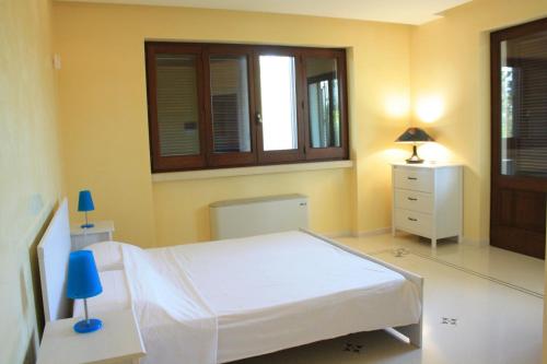 a bedroom with a white bed and a window at Relais il Melograno in Arnesano