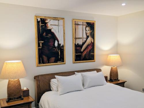 a bedroom with two paintings on the wall and a bed at ONE Luxury Apartment in Devonport