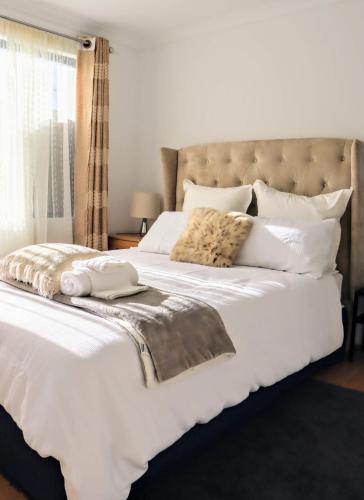 a bedroom with a large bed with white sheets and pillows at Bj comfy home in Wellard