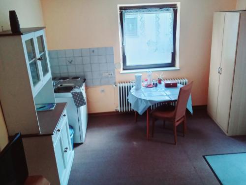 uma pequena cozinha com uma mesa e um lavatório em Möbliertes Zimmer em Nurembergue