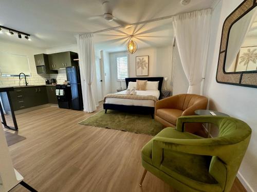 - un salon avec un lit et une chaise dans l'établissement Luxe Palm Studio Villa - In the heart of Edge Hill, à Edge Hill