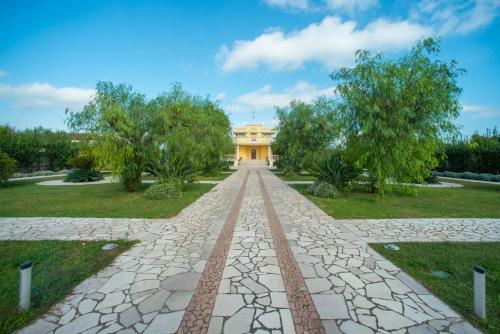 a walkway in front of a yellow building at Relais il Melograno in Arnesano