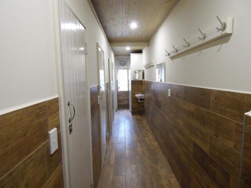 a hallway of a bathroom with wooden floors and a toilet at The Tree Top Village Urban Glamping in St Lucia