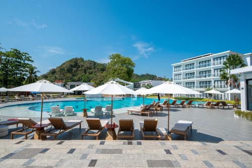 瑤亞島的住宿－Royal Yao Yai Island Beach Resort，一个带椅子和遮阳伞的游泳池以及酒店
