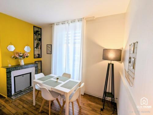 une salle à manger avec une table et des chaises et une cheminée dans l'établissement Ô plaisir des sens * Jardin * Parking * Plain-pied, à Orléans