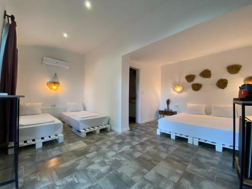 Habitación con 2 camas, paredes blancas y suelo de baldosa. en Çıralı Marina Loft, en Cıralı