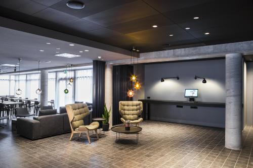 a lobby with a waiting room with chairs and a table at Skuggi Hotel by Keahotels in Reykjavík